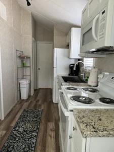 cooking area with stove, oven, refrigerator and other appliances 2 - full house park model manufacturer demo